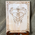 Wood plaque with an interlace heart design on a stand