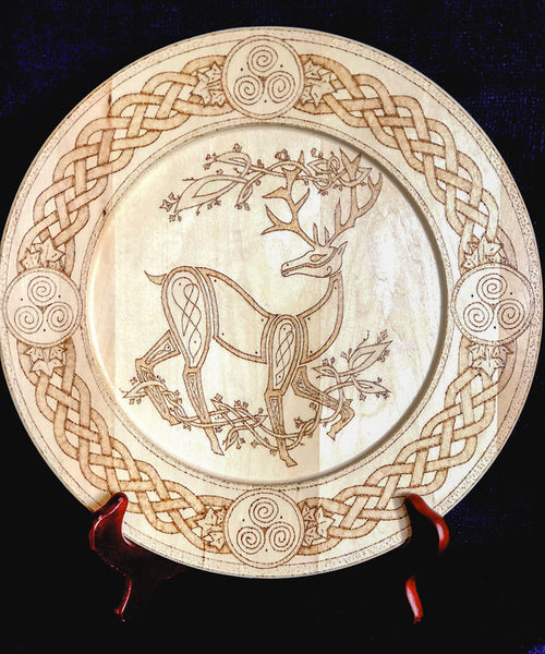Decorative plate with a deer and Celtic knot design on a black background