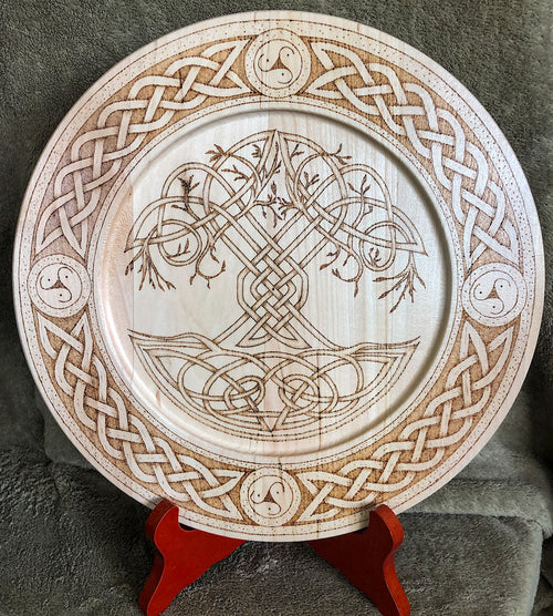 Decorative wooden plate with Celtic knot tree of life design on a stand