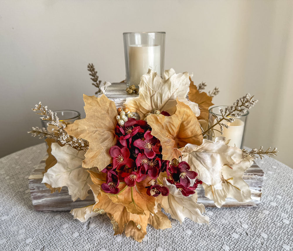 Festive three-tiered wooden candleholder with faux autumn flowers and leaves