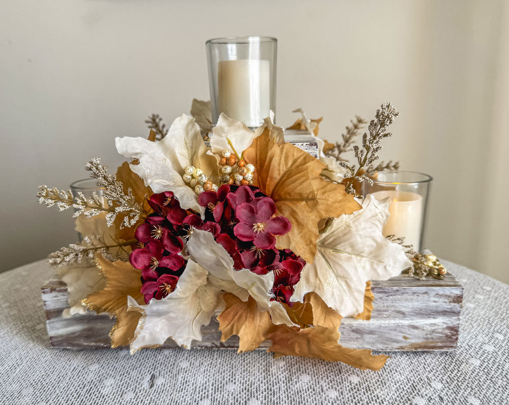 Festive three-tiered wooden candleholder with faux autumn flowers and leaves