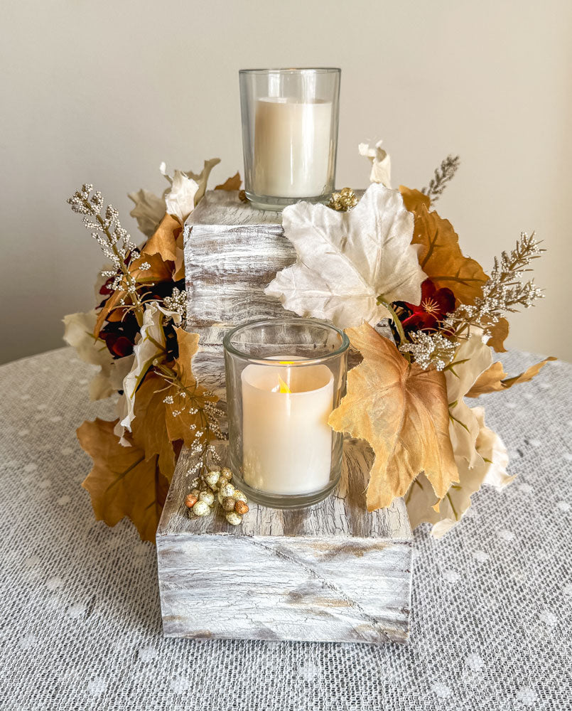Festive three-tiered wooden candleholder with faux autumn flowers and leaves