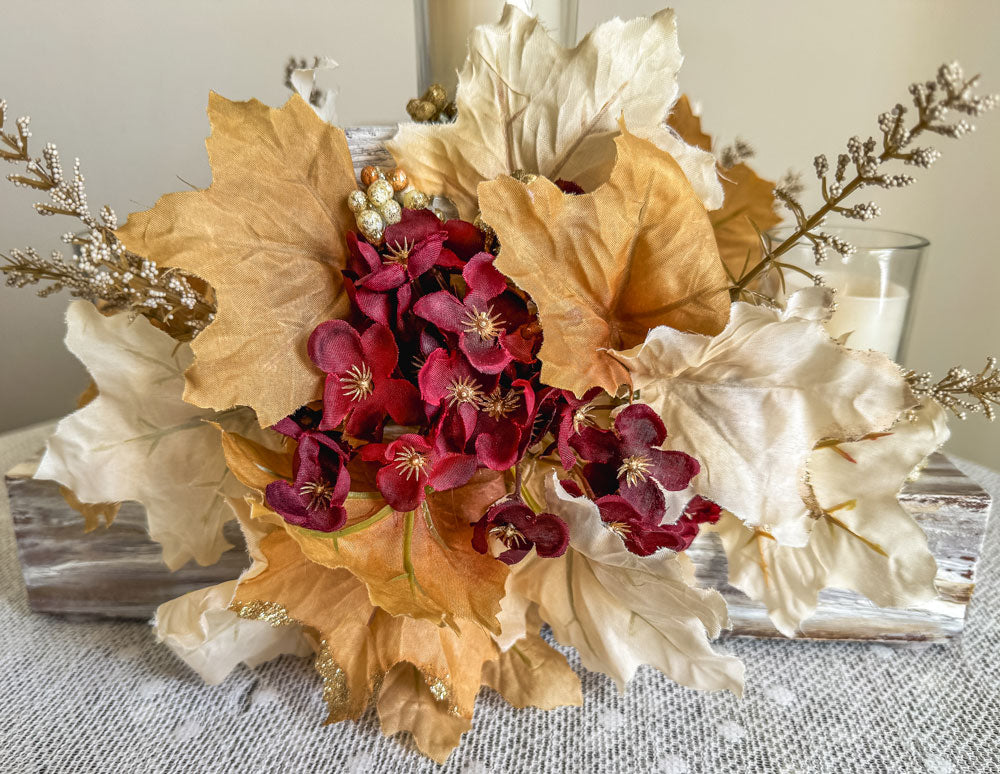 Festive three-tiered wooden candleholder with faux autumn flowers and leaves