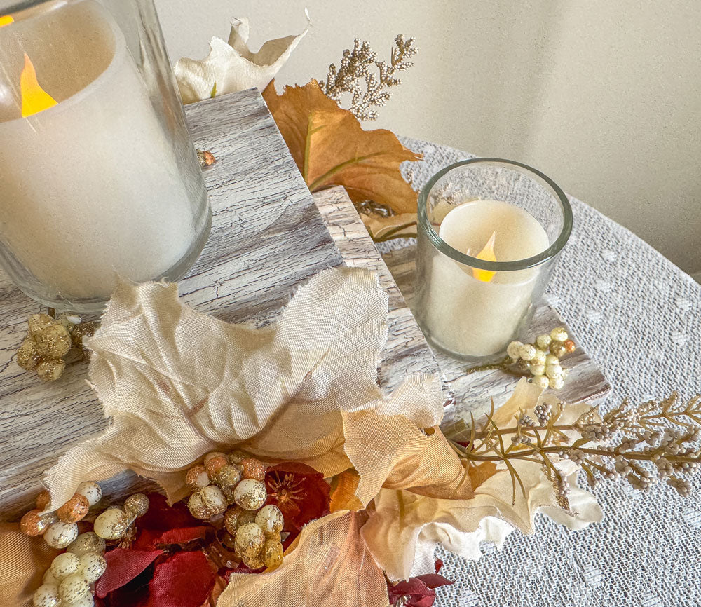 Festive three-tiered wooden candleholder with faux autumn flowers and leaves