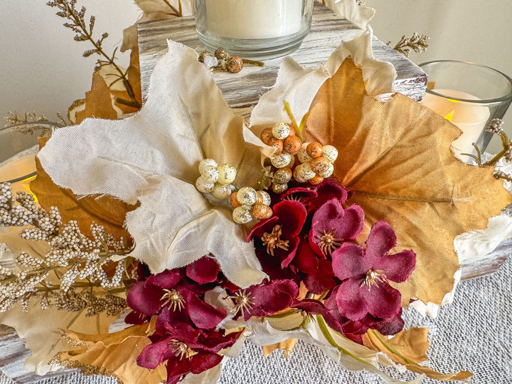 Festive three-tiered wooden candleholder with faux autumn flowers and leaves