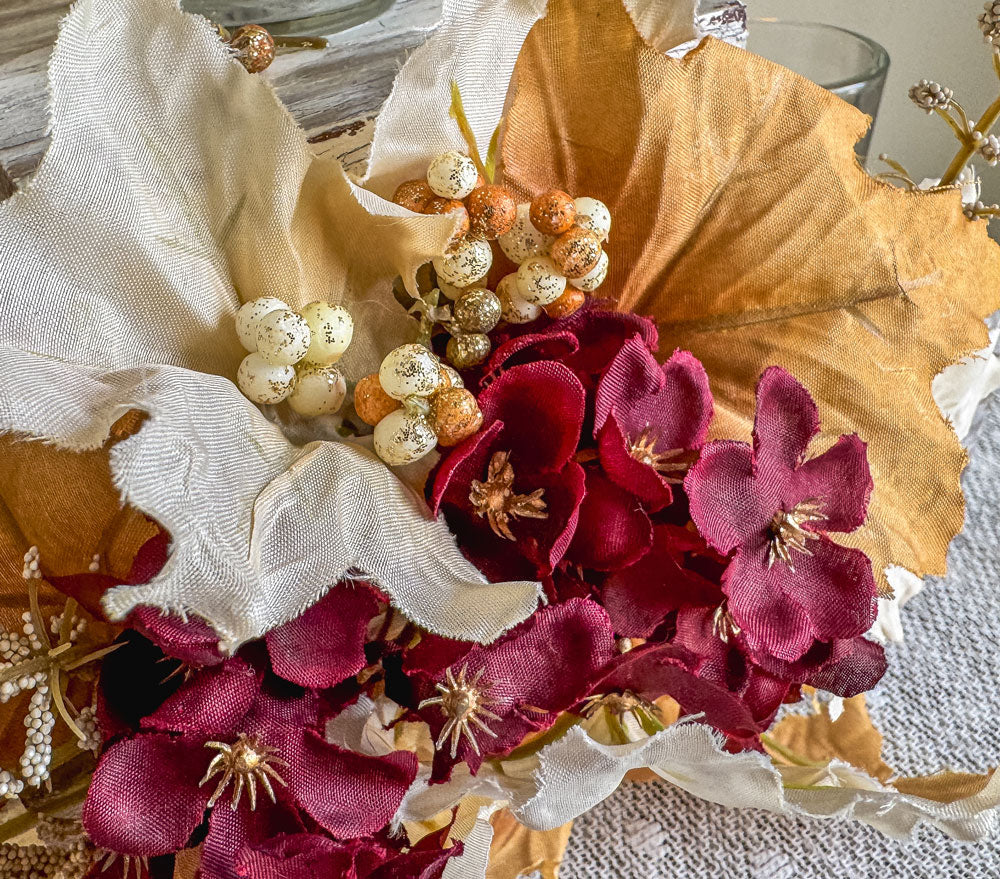 Festive three-tiered wooden candleholder with faux autumn flowers and leaves