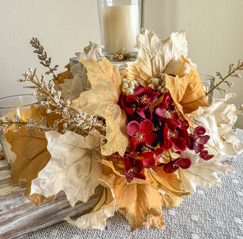 Festive three-tiered wooden candleholder with faux autumn flowers and leaves