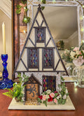 Miniature half timber house with stained glass windows on a table
