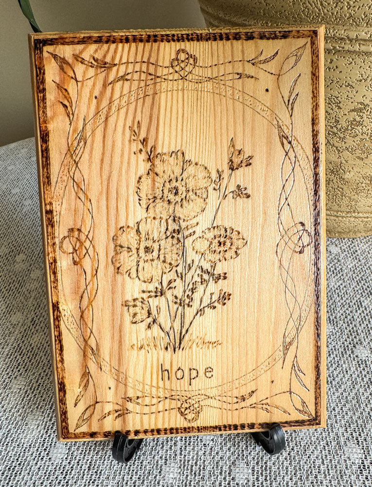 Small wood plaque with anemones and the word hope on a stand