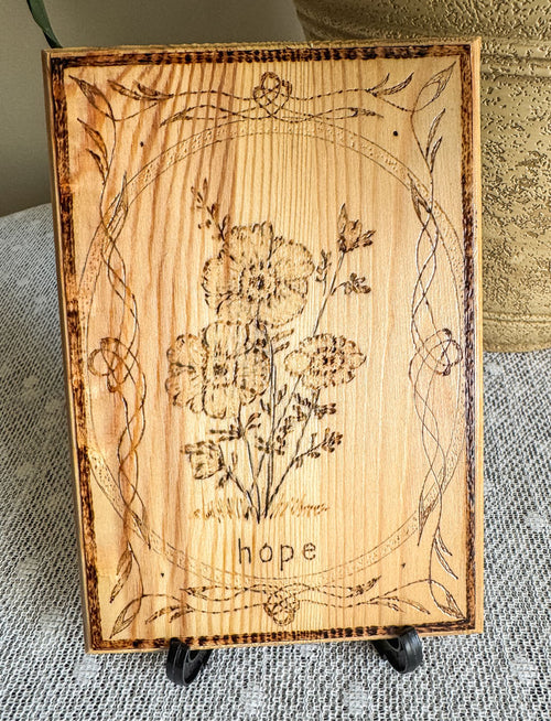 Small wood plaque with anemones and the word hope on a stand