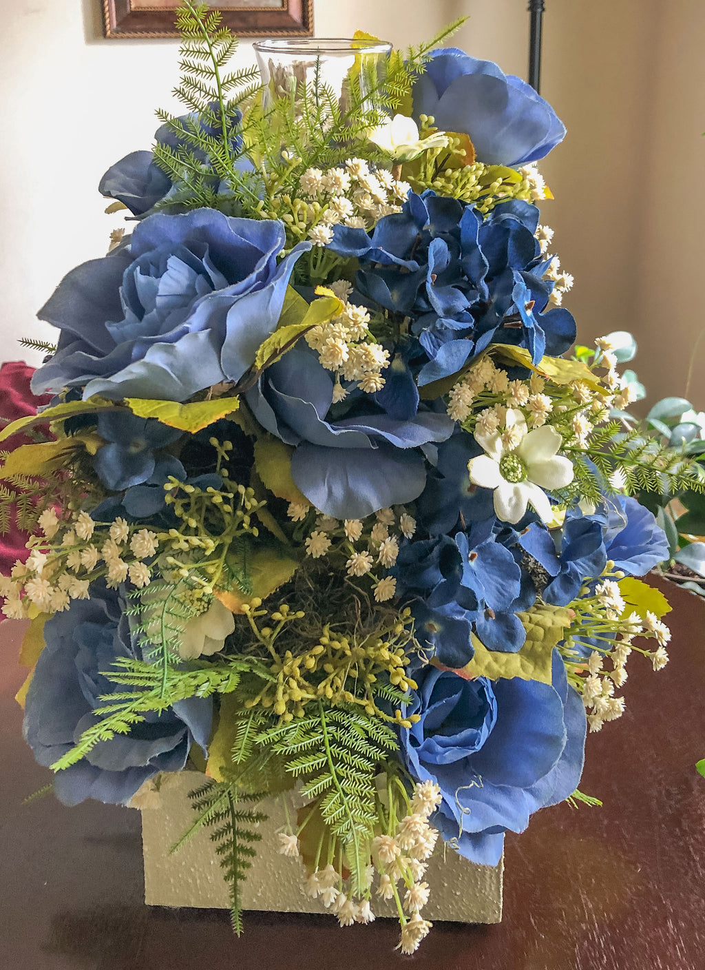 Candle holder with faux blue and cream florals on a table