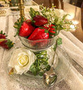 Artificial strawberries with white roses and  ivy in a dessert cup on a glass plate