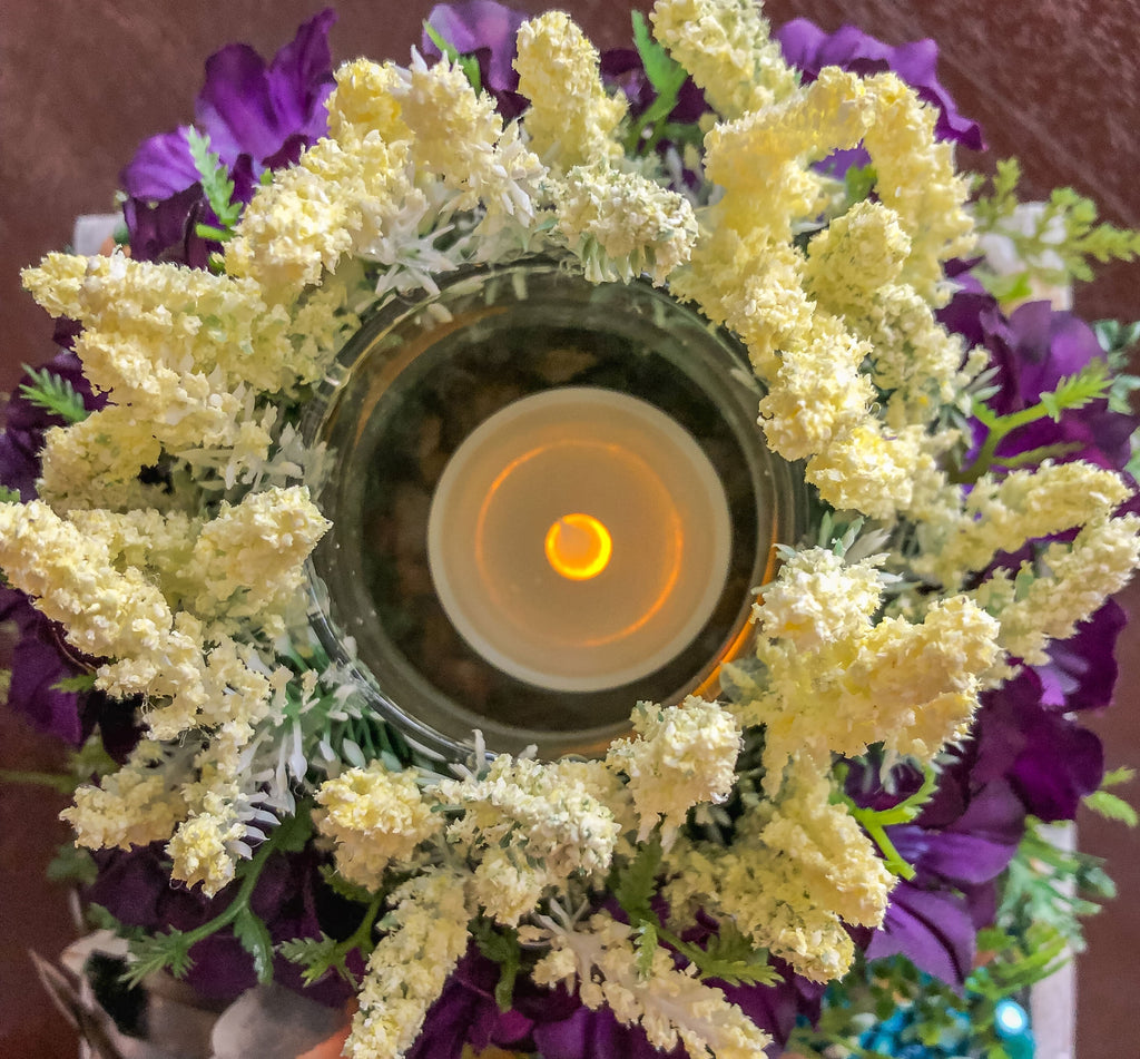 Candleholder with white and purple faux florals and a bird