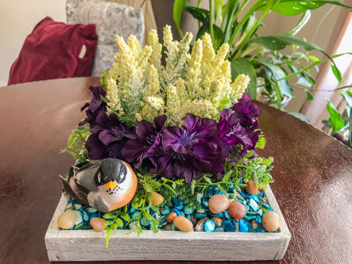 Candleholder with white and purple faux florals and a bird
