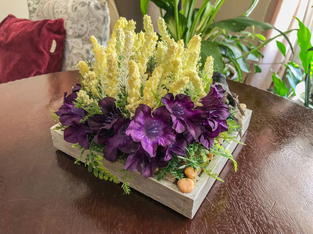 Candleholder with white and purple faux florals and a bird