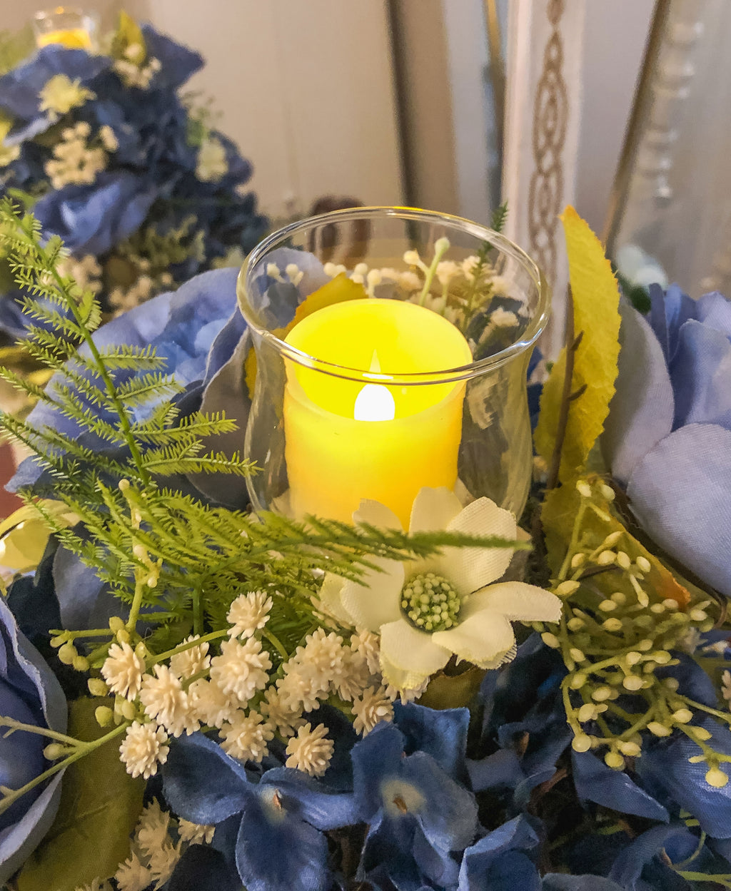 Wood candleholder with blue fabric rose and hydrangea arrangement