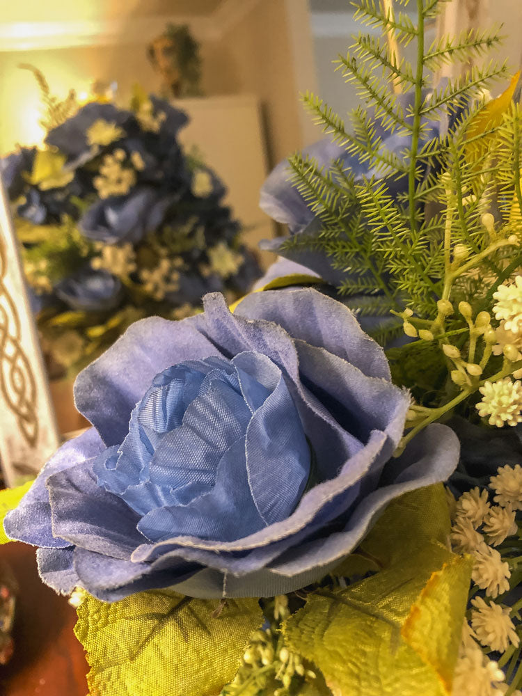 Wood candleholder with blue fabric rose and hydrangea arrangement