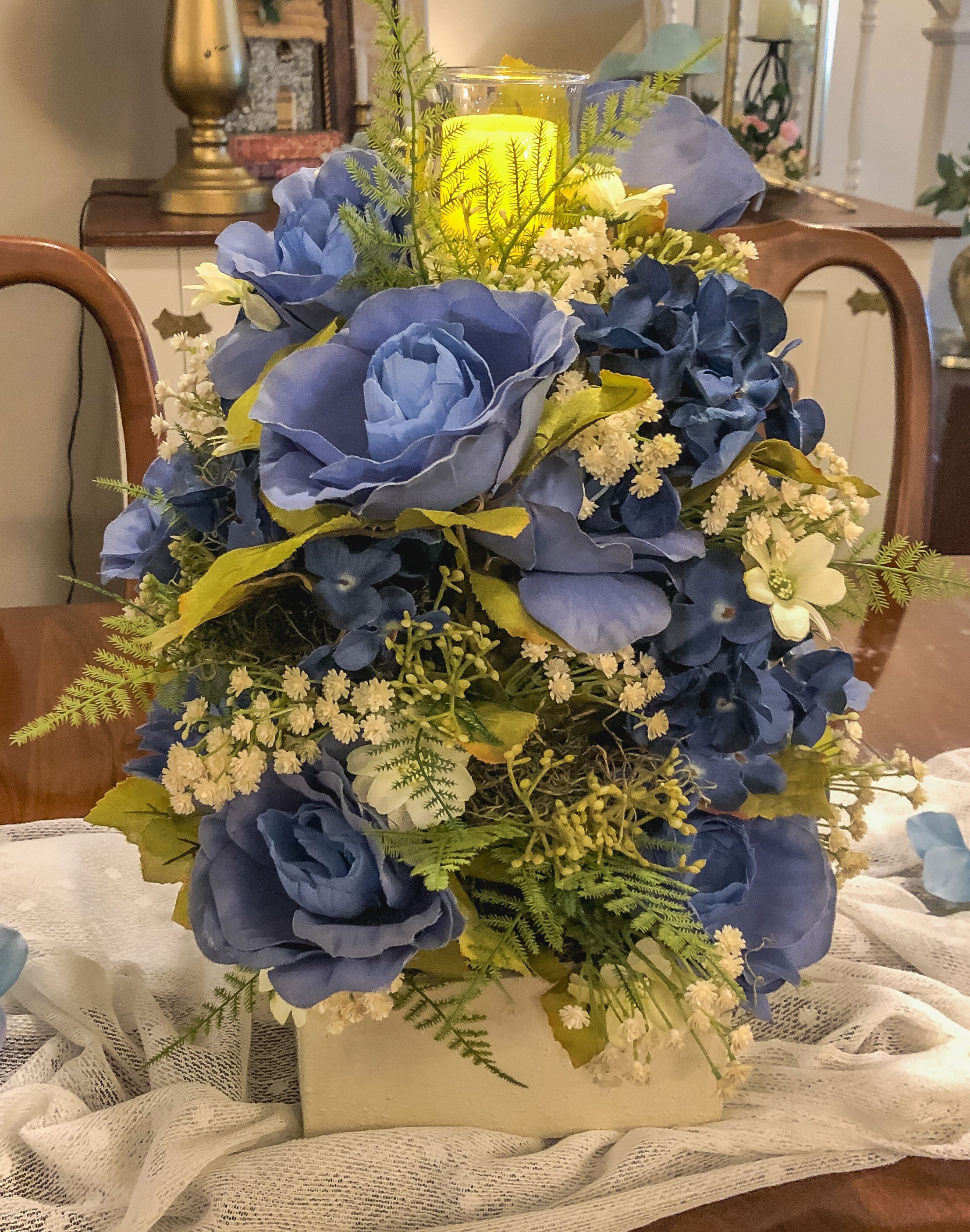 Wood candleholder with blue fabric rose and hydrangea arrangement