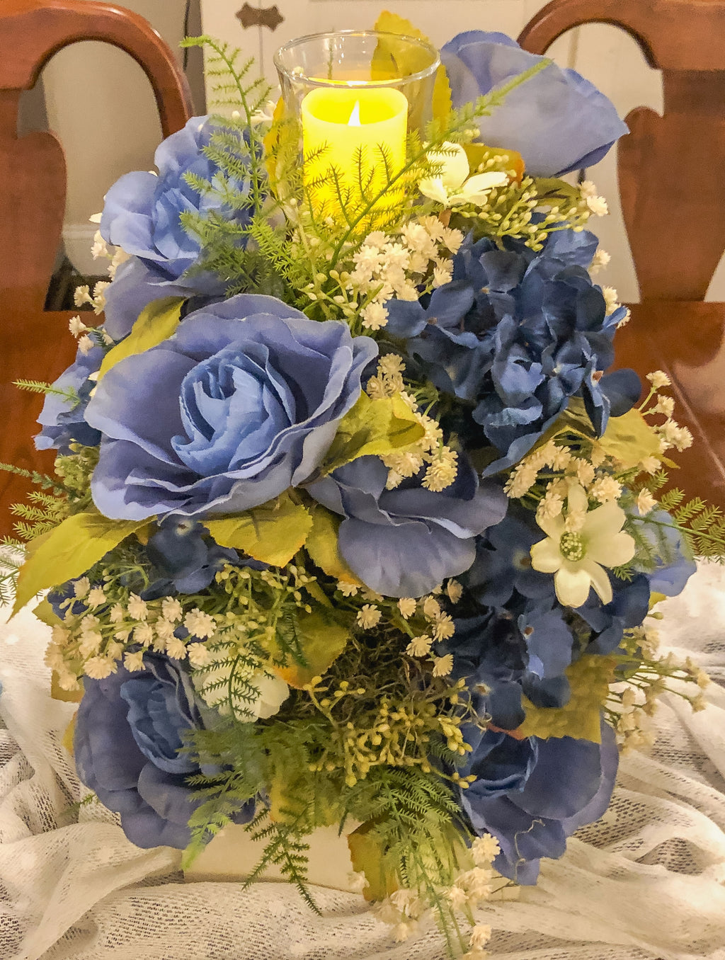 Wood candleholder with blue fabric rose and hydrangea arrangement