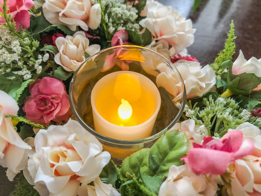 Votive candleholder with miniature coral roses in a tray