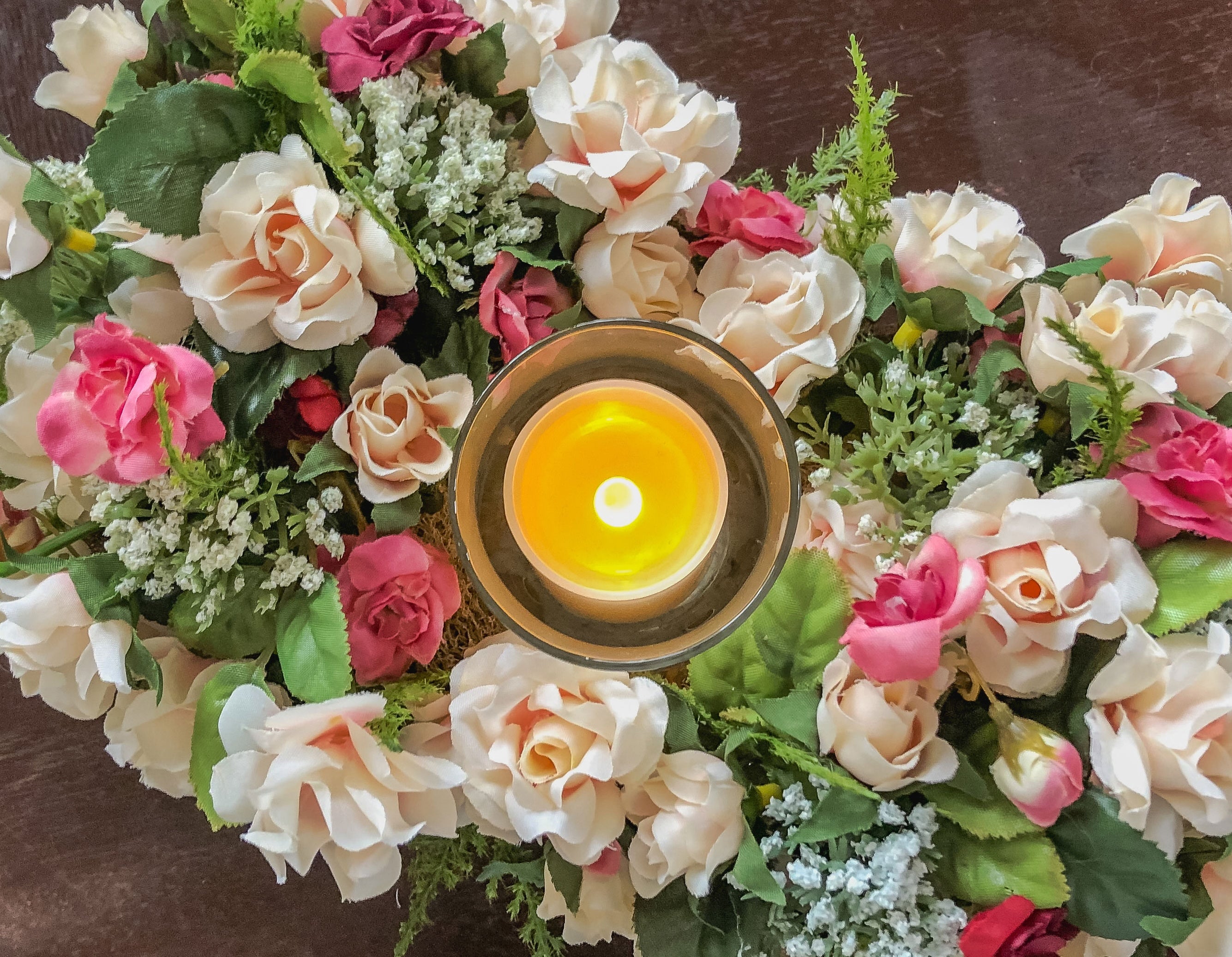 Votive candleholder with miniature coral roses in a tray