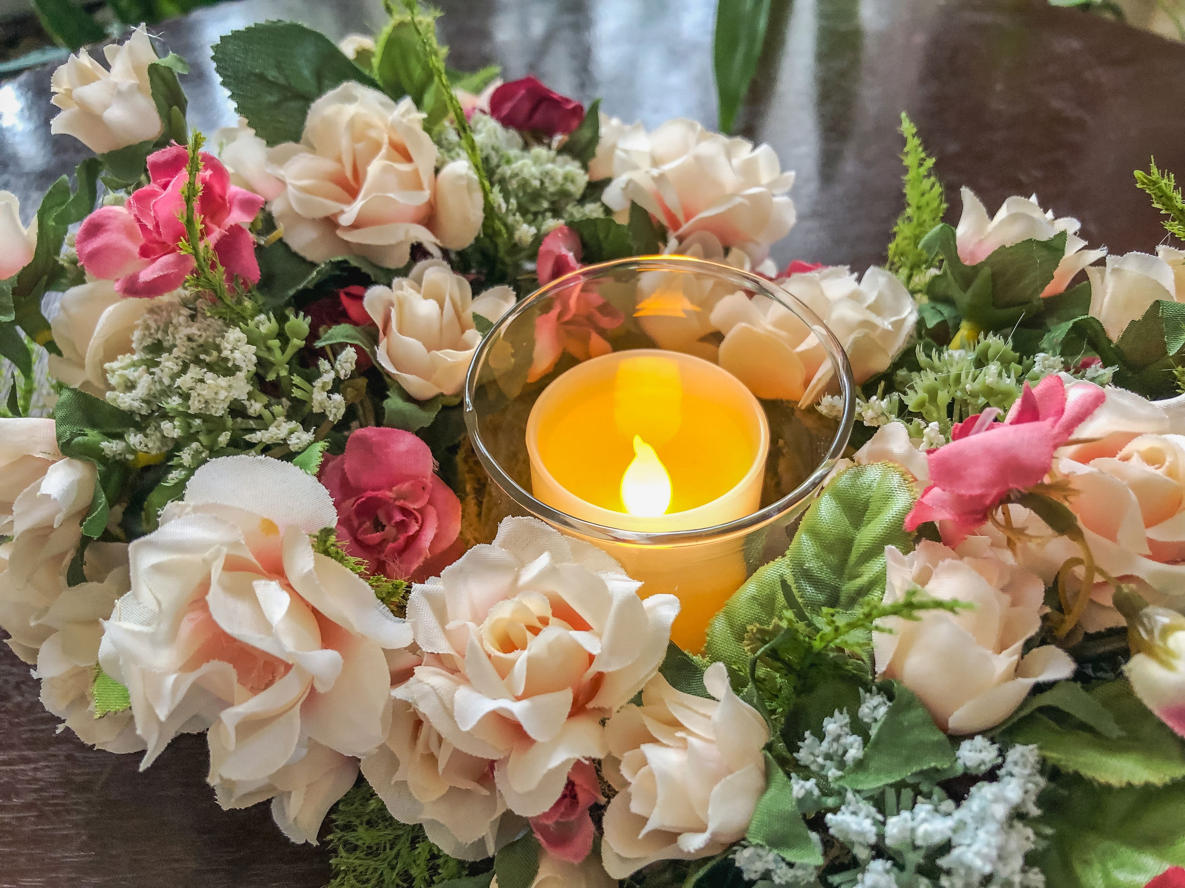 Votive candleholder with miniature coral roses in a tray