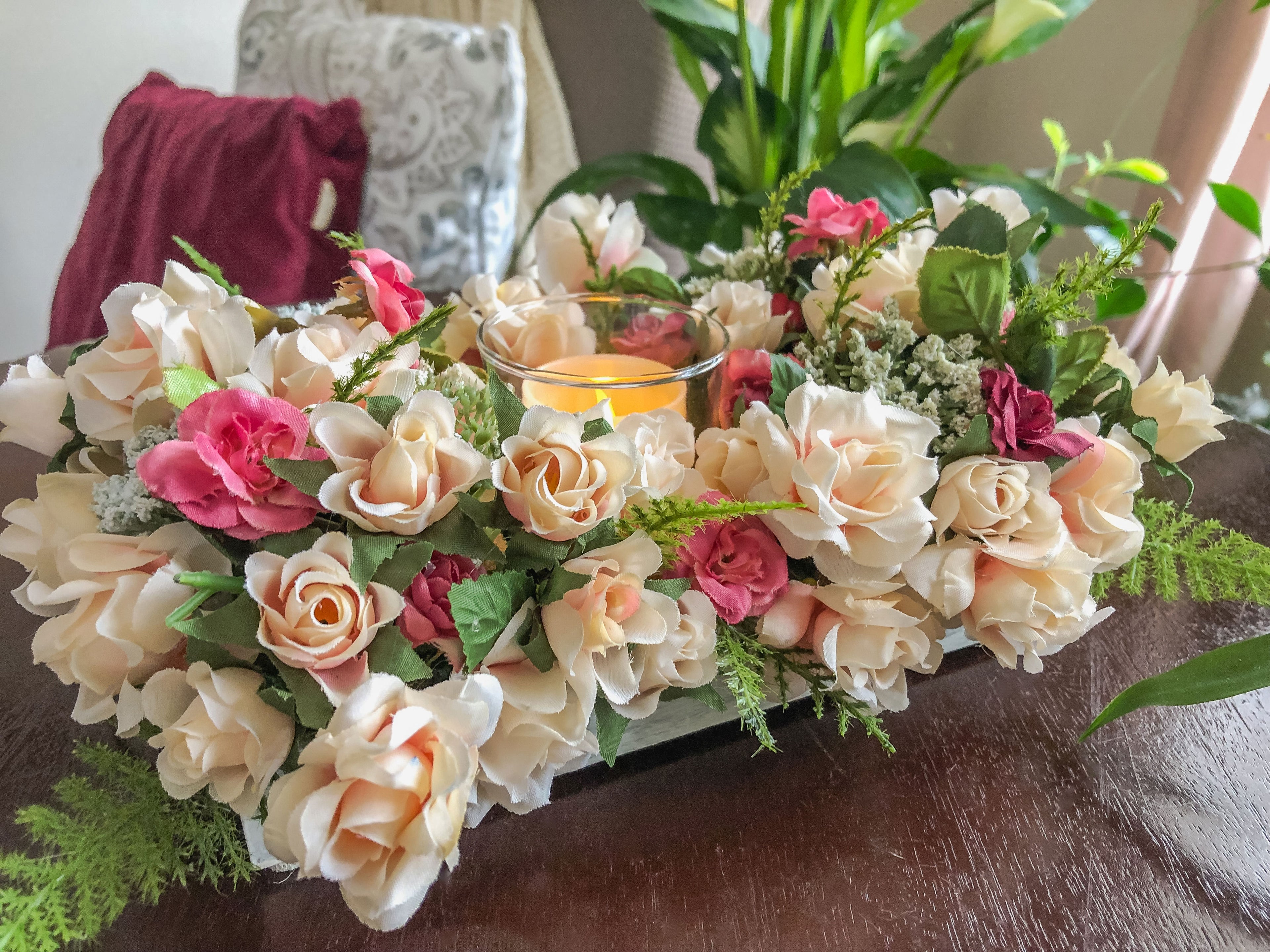 Votive candleholder with miniature coral roses in a tray