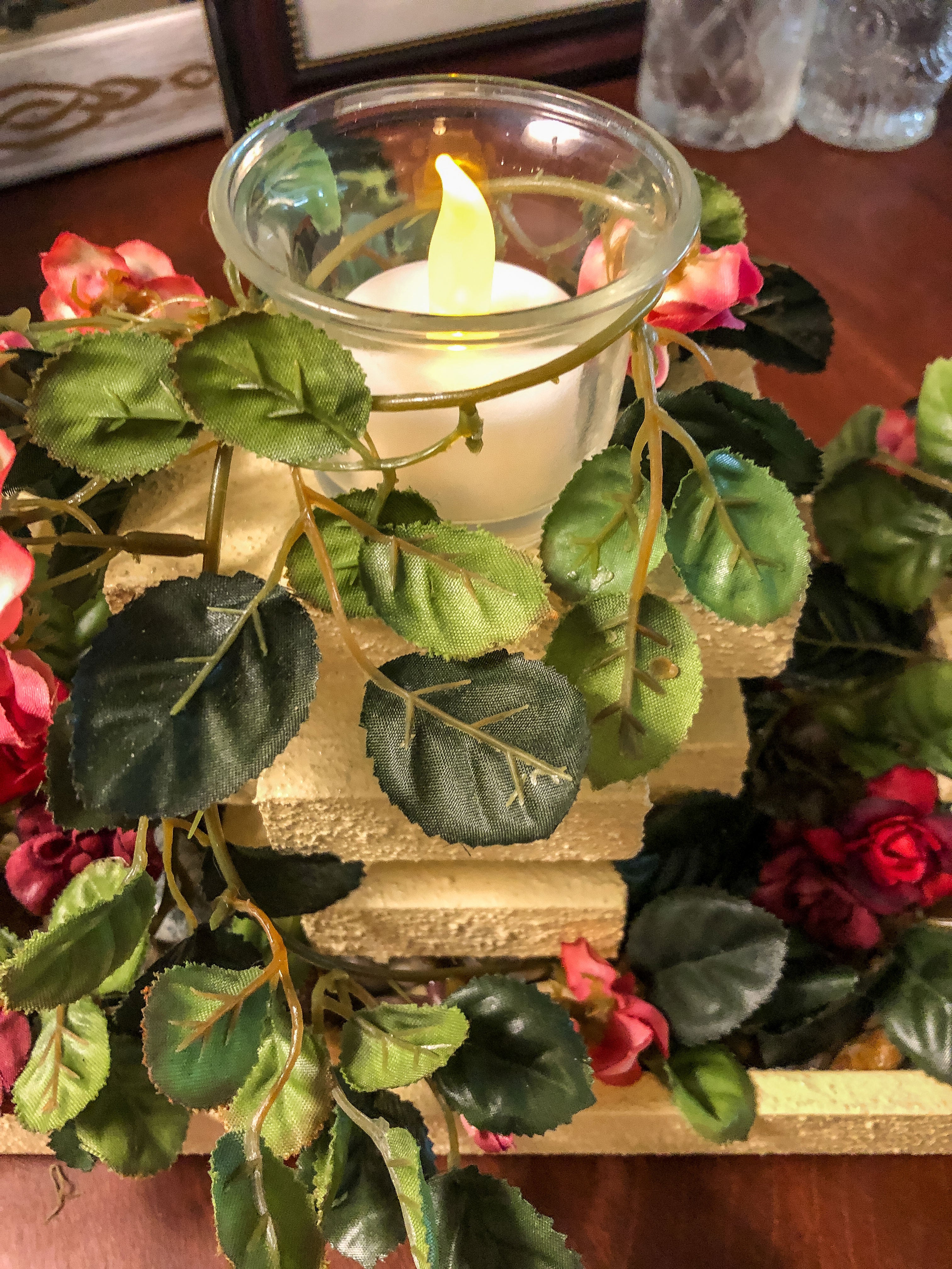 Wood candleholder with three garden pillars covered with miniature pink roses