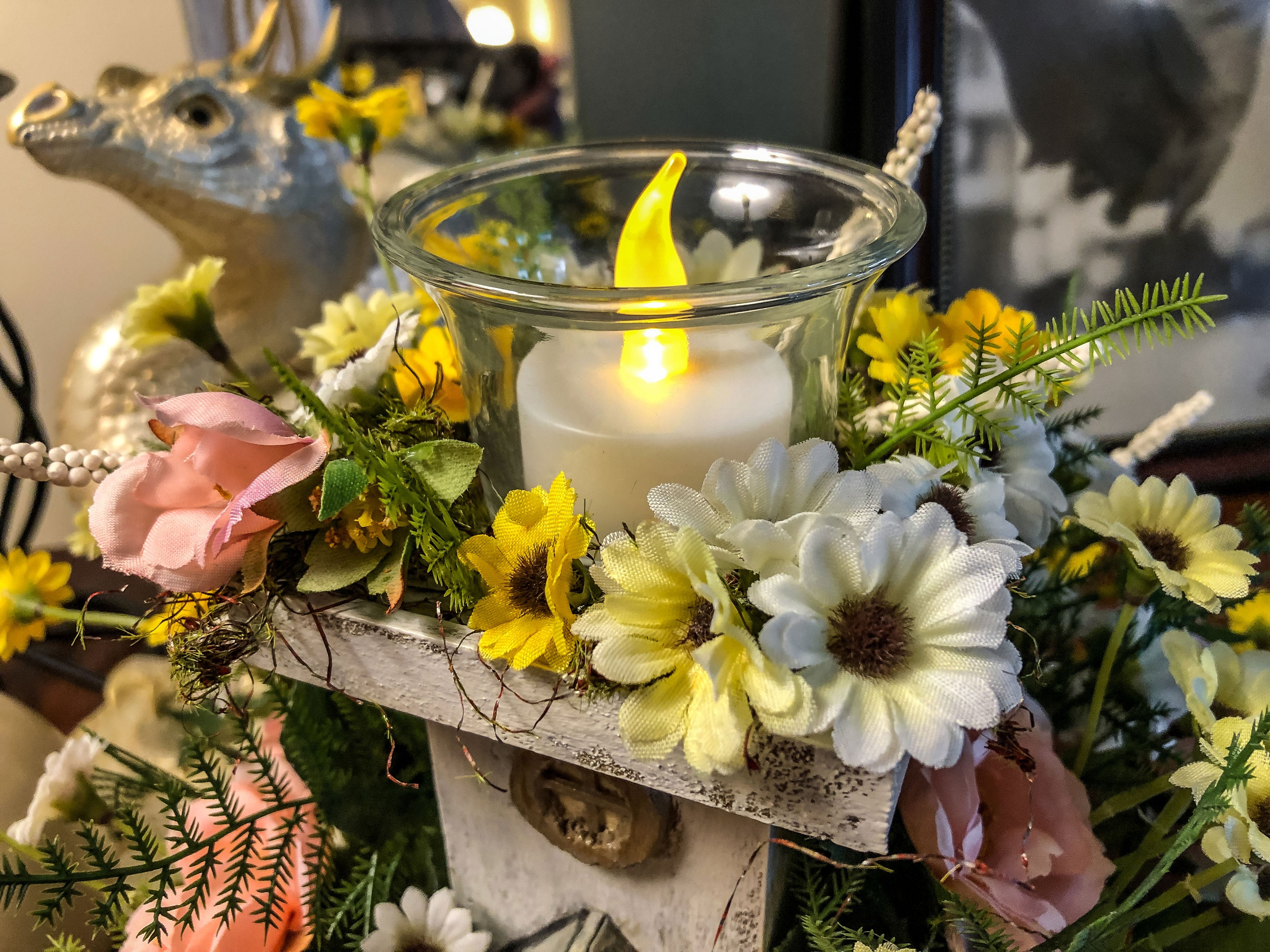 Wood candleholder with a miniature fairy tower in a flower bush