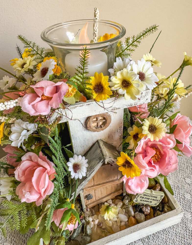 Wood candleholder with a miniature fairy tower in a flower bush