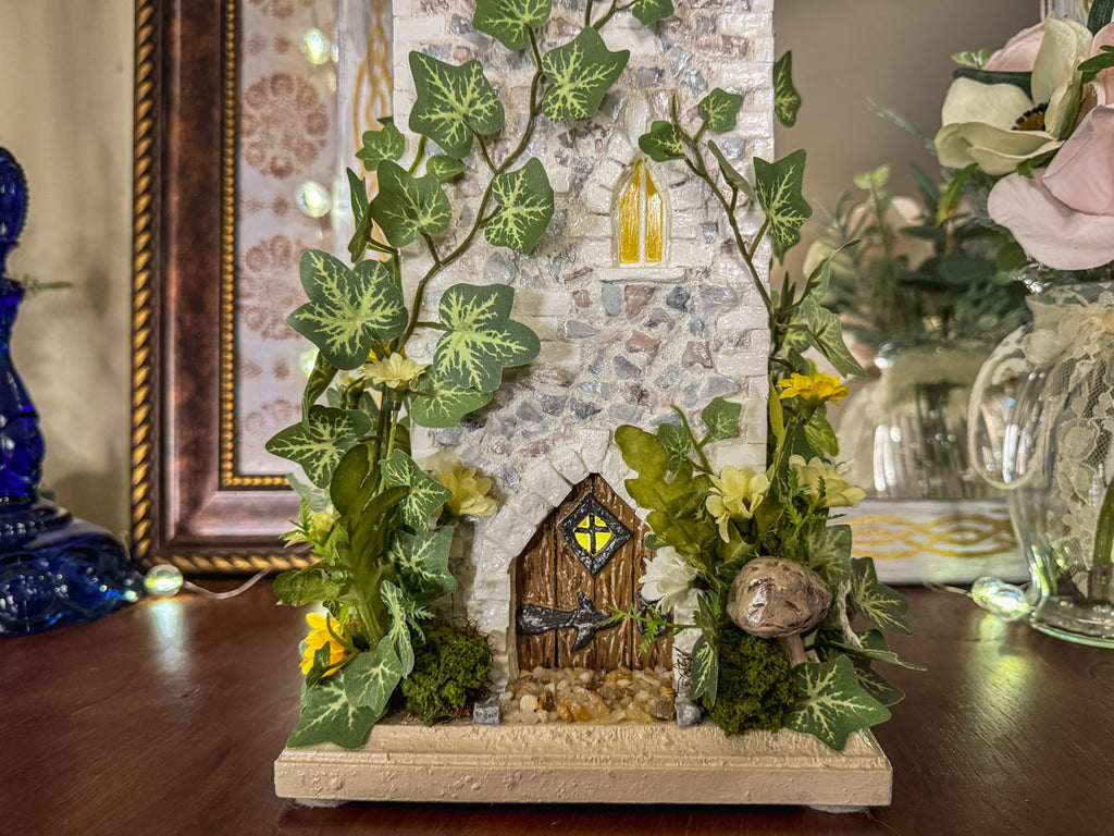 Handcrafted wood and stone fairy castle with faux florals