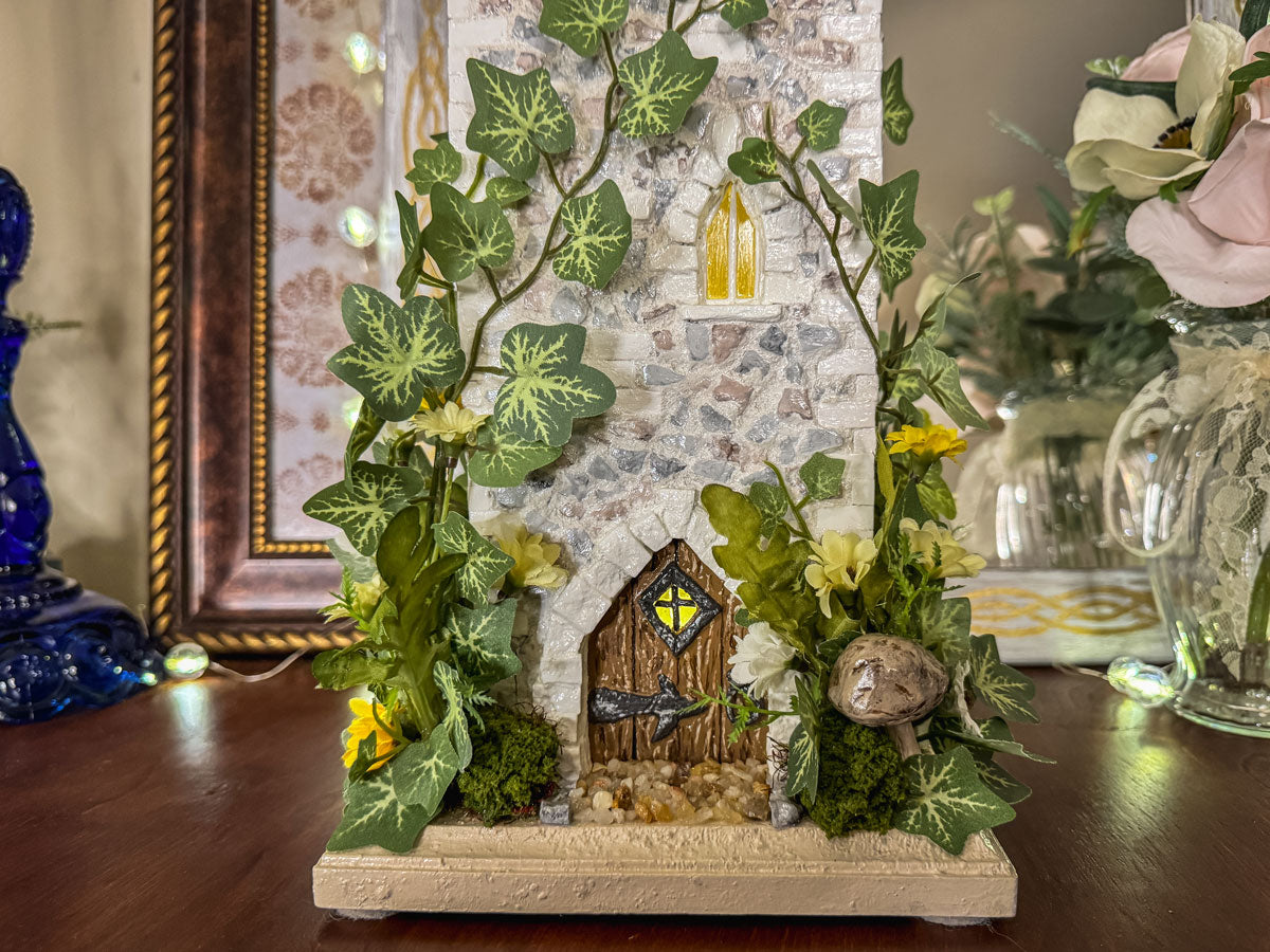 Handcrafted wood and stone fairy castle with faux florals
