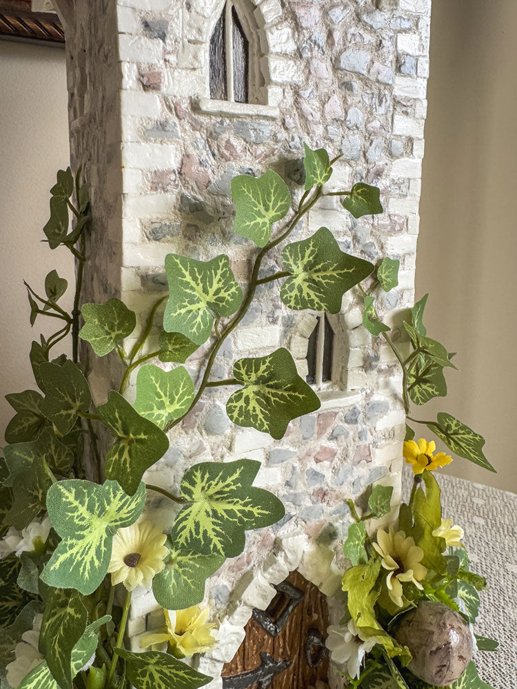 Handcrafted wood and stone fairy castle with faux florals