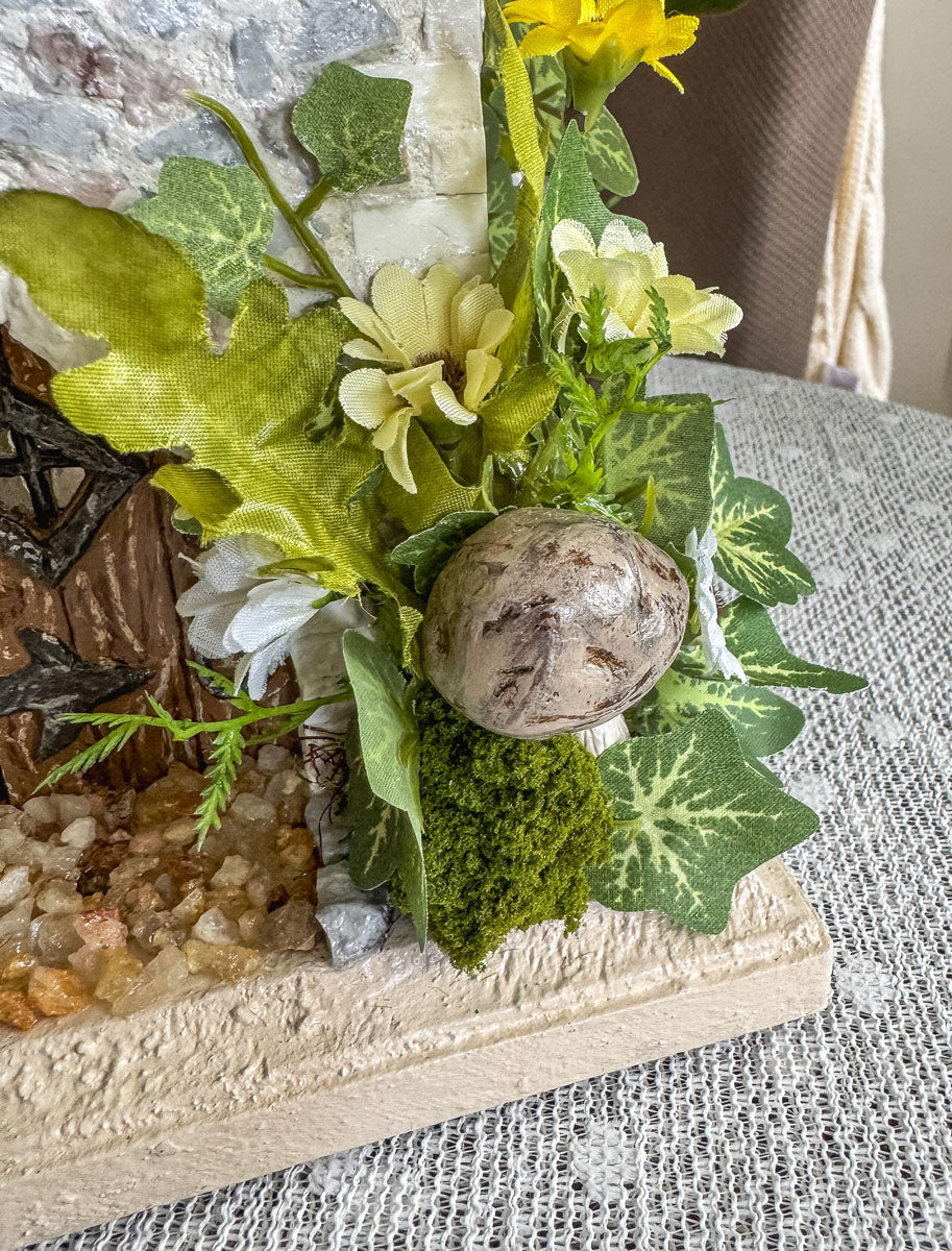 Handcrafted wood and stone fairy castle with faux florals