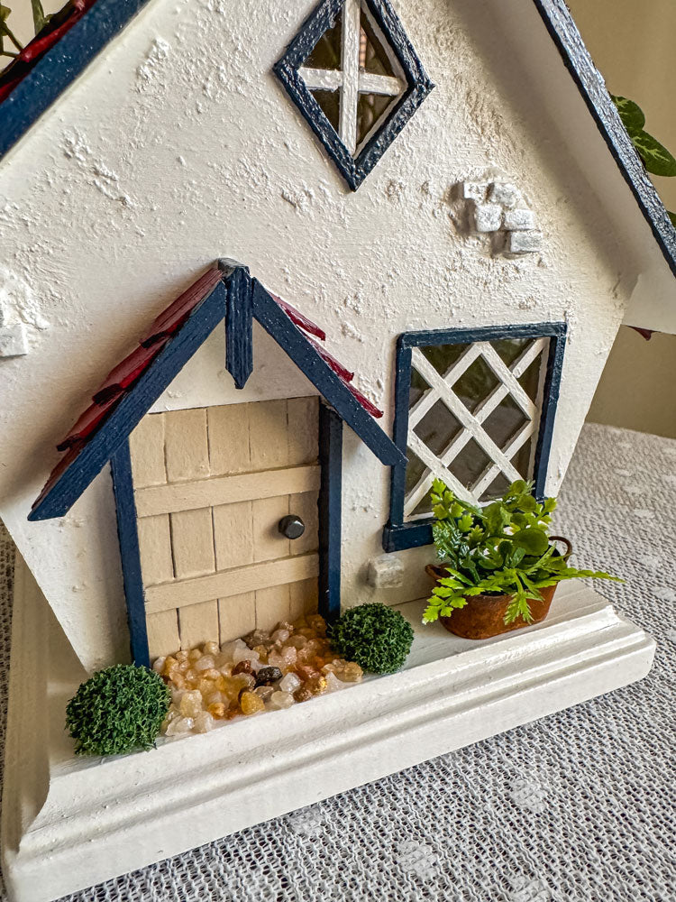 Red, white, and blue woodland fairy cottage with drop gable