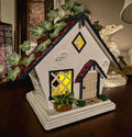 Miniature red white and blue cottage with faux ivy on a table