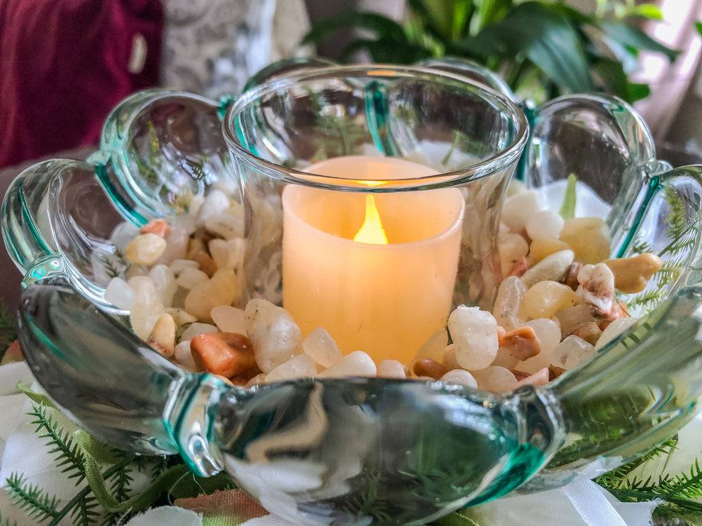 Votive candleholder with a striped glass bowl ringed with white roses