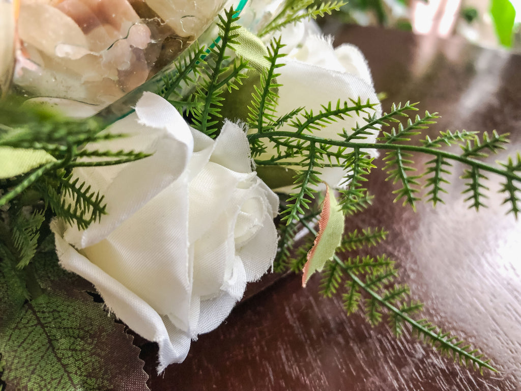 Votive candleholder with a striped glass bowl ringed with white roses