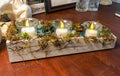 Wood candleholder with blue rocks and moss on a table