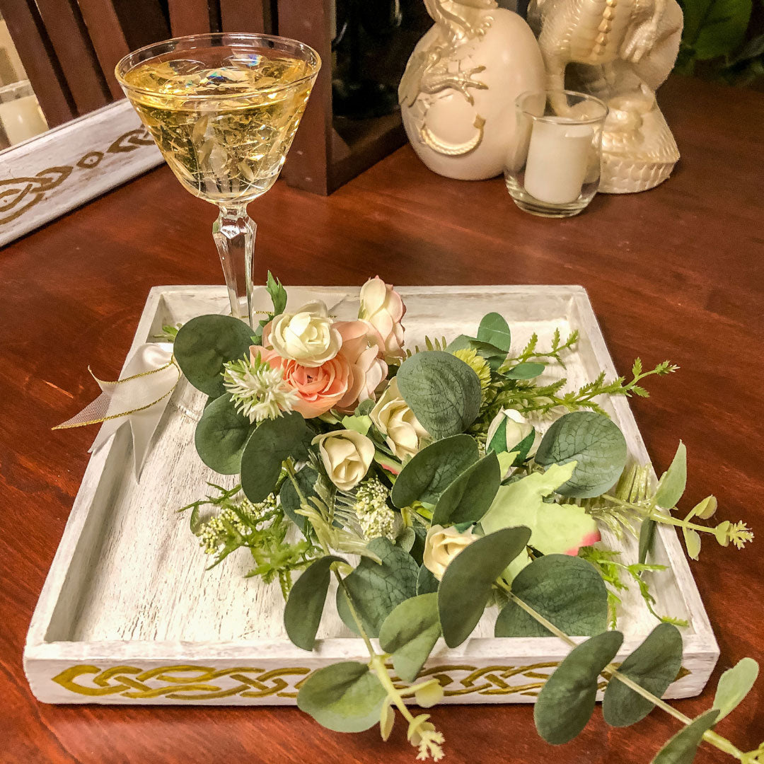Wedding-inspired faux floral display with up-cycled champagne glass in a tray