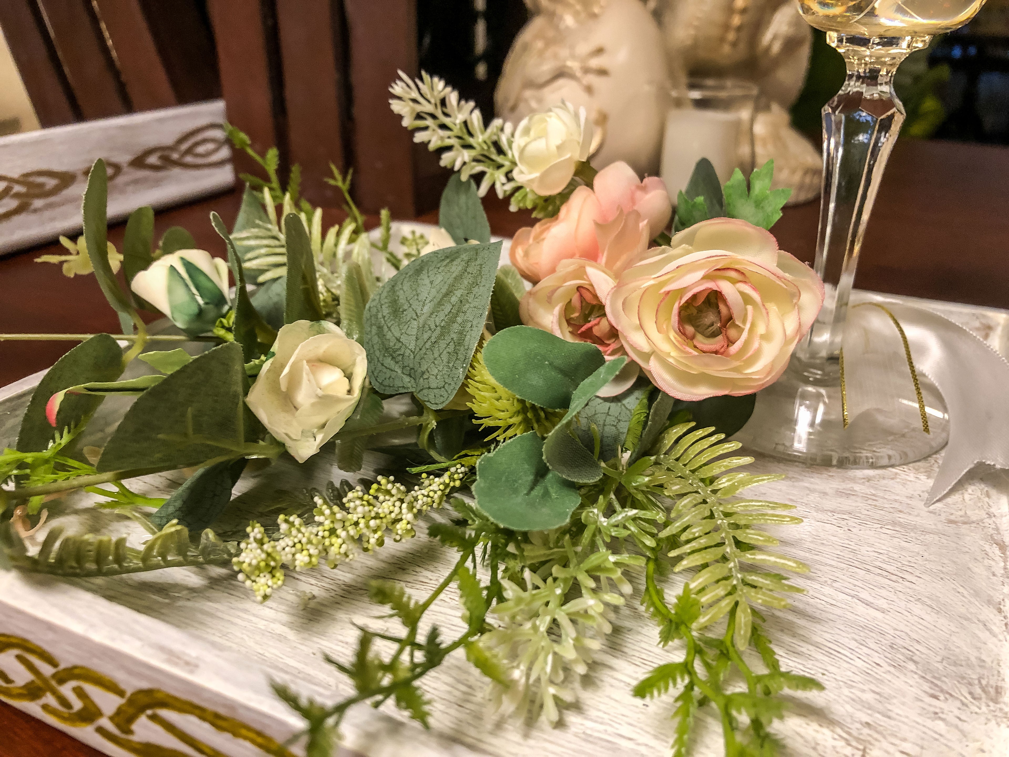 Wedding-inspired faux floral display with up-cycled champagne glass in a tray