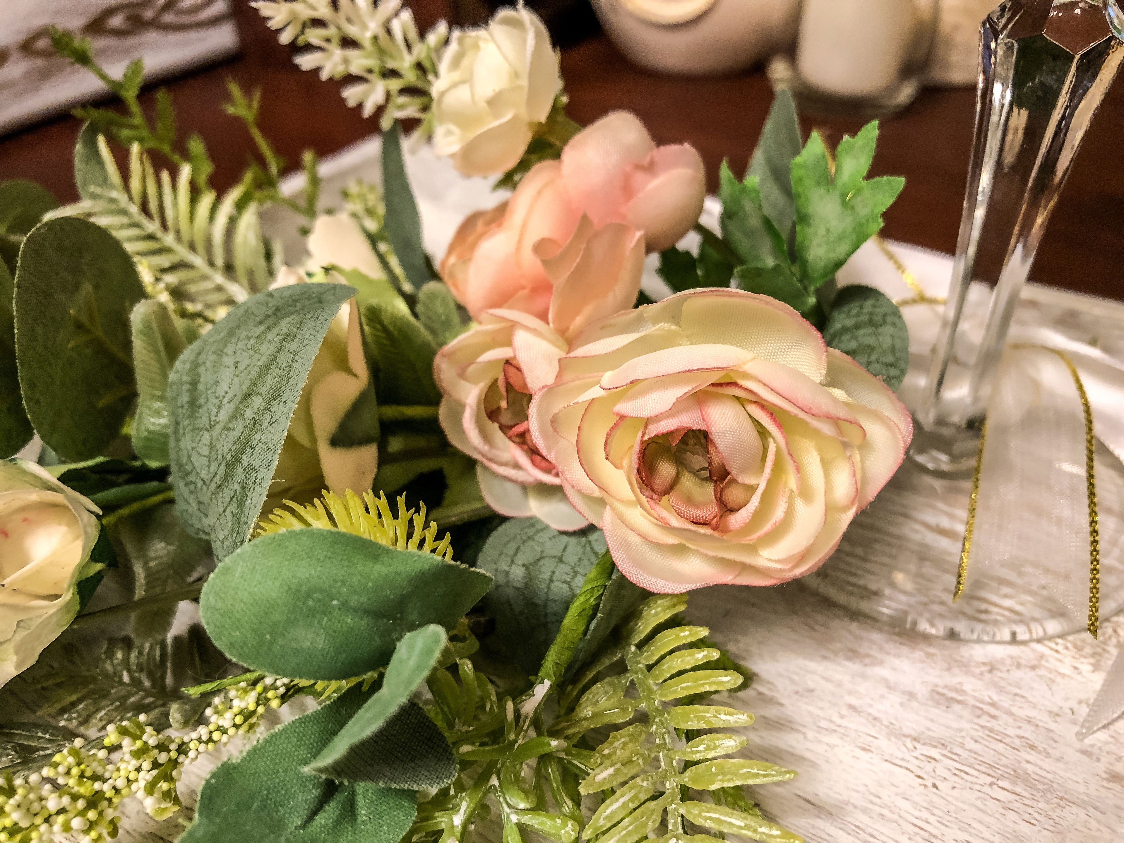 Wedding-inspired faux floral display with up-cycled champagne glass in a tray
