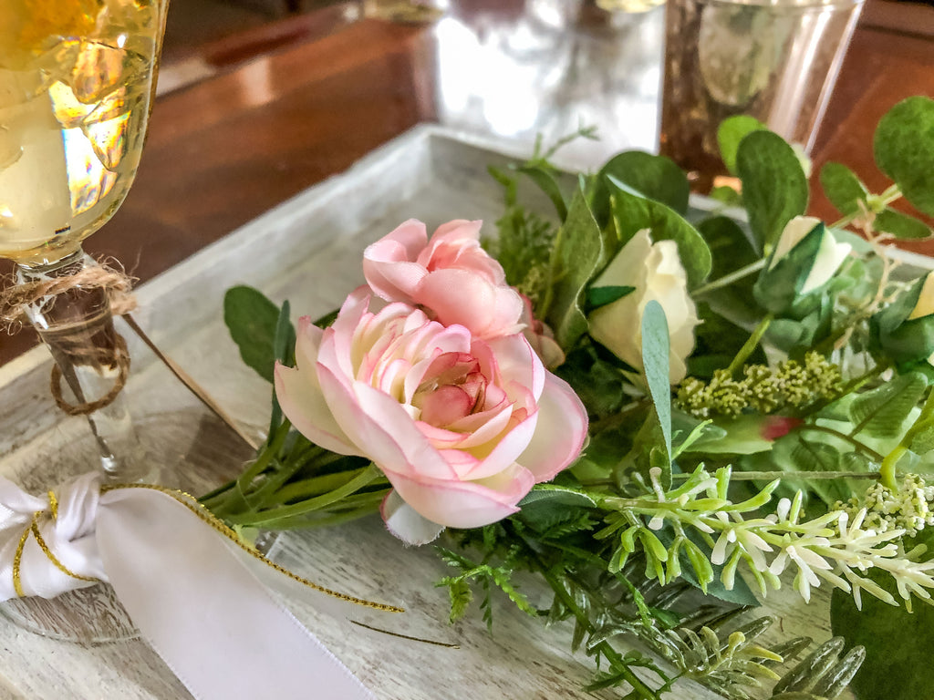 Wedding-inspired faux floral display with up-cycled champagne glass in a tray
