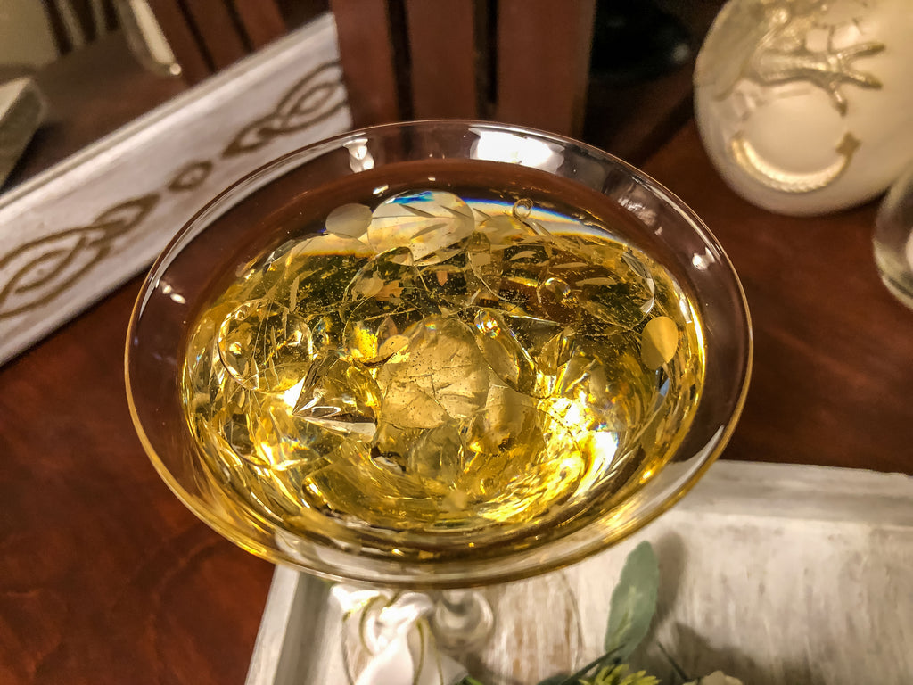 Wedding-inspired faux floral display with up-cycled champagne glass in a tray