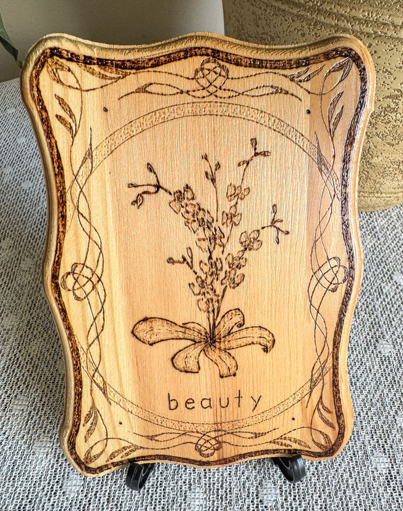 Small wood plaque with an orchid and the word beauty on a stand